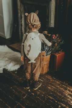 a small child wearing a backpack with a cat on it