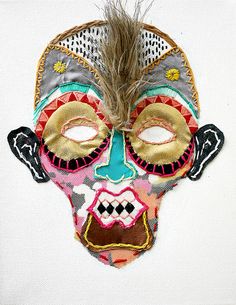 a mask with feathers on top of it