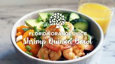 a white bowl filled with shrimp and veggies next to a glass of orange juice