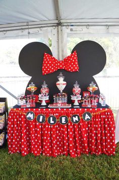 a minnie mouse themed birthday party with red and white polka dot table cloths, mickey mouse