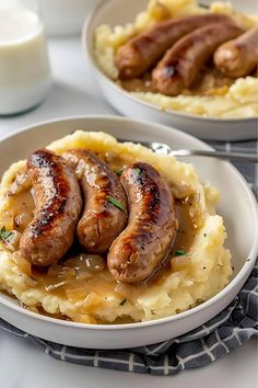 two white plates topped with mashed potatoes and sausage