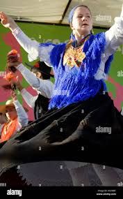 a woman in blue and white is dancing on stage with other people behind her - stock image