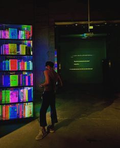 a woman standing in front of a book shelf with colorful books on it's shelves