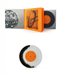 an orange and white record is next to a black and white cd case with the same design on it