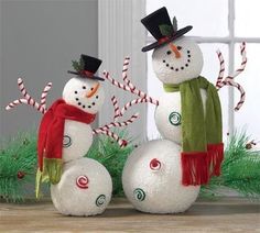 two snowmen with hats and scarves on their heads