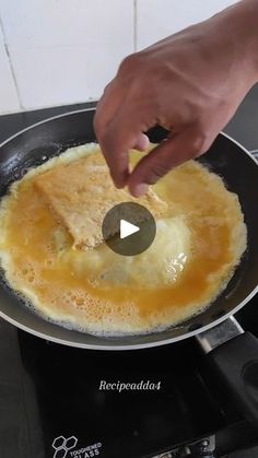 someone is frying an omelet in a pan on top of the stove