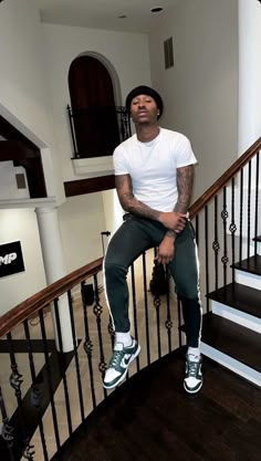 a man sitting on top of a stair case next to a banister in a house