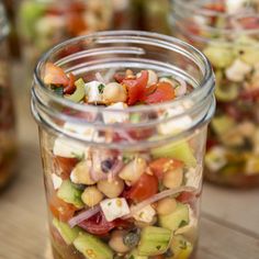 several jars filled with different types of food on top of a wooden table next to each other