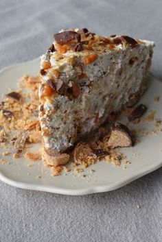 a piece of cake sitting on top of a plate covered in nuts and crumbs