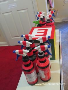 red and white fire extinguishers are lined up on a table in front of a door