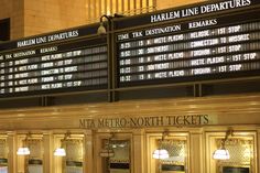 there are many signs on the wall above the ticket booth at the train station in new york city