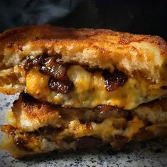 two grilled sandwiches stacked on top of each other with cheese and meat in them