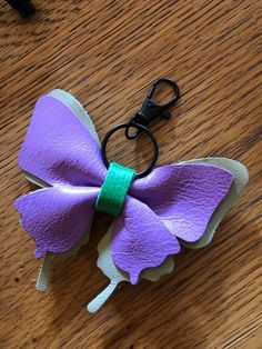 a purple and white bow on a pair of scissors sitting on top of a wooden table