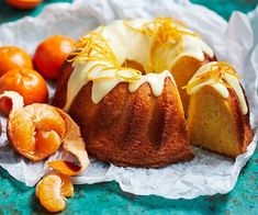 a bundt cake with icing and oranges around it