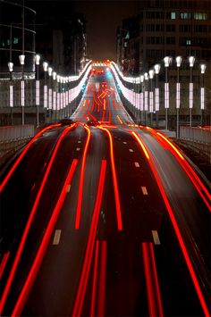 long exposure photograph of city street at night with red and white light streaks on the road