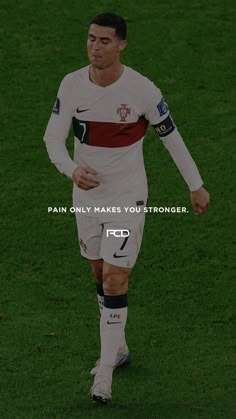 a soccer player is running with the ball in his hand and an ad that says pain only makes you stronger