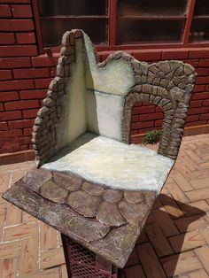 a chair made out of rocks sitting on top of a brick floor