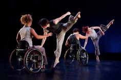 dancers in wheelchairs performing on stage with one person pushing the wheel chair behind them