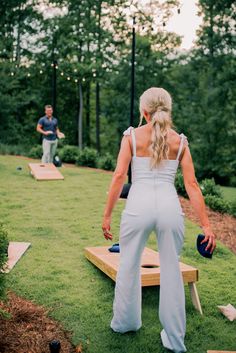 a woman standing on top of a wooden board