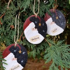 three ornaments hanging from a christmas tree with the words believe and santa clause on them