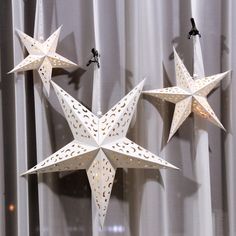 three white paper stars hanging from the ceiling