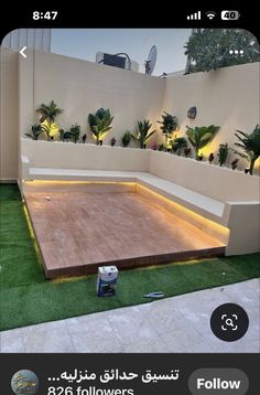 an outdoor area with artificial grass and lights on the ground, surrounded by fake plants