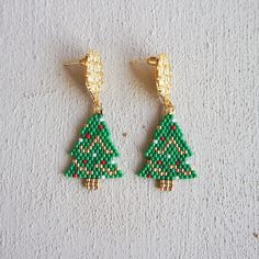 Our  Beaded Christmas Tree Earrings with Miyuki Delicas  are the perfect Christmas jewelry for a festive look!  Each earring is carefully handcrafted with tiny, colorful Miyuki Delica beads to create a charming Christmas tree design. These earrings are like wearing a piece of holiday magic on your ears!  Our Christmas tree earrings are lightweight and easy to wear. They dangle gently, so you can show off your holiday spirit with every step you take. 🎉💃 Whether you're getting ready for a holiday party, school play, or just want to add a touch of Christmas cheer to your outfit, these earrings are the perfect choice. You'll sparkle and shine like a star atop a beautifully decorated tree.  Give the gift of Christmas joy with these delightful earrings. They come in a cute little box, ready to Handmade Earrings For Holiday Festivities, Handmade Beaded Earrings For Christmas Gift, Handmade Gold Christmas Earrings, Handmade Gold Earrings For Christmas, Christmas Gift Beaded Drop Earrings, Holiday Handmade Beaded Earrings Gift, Handmade Beaded Earrings For Holiday Gifts, Handmade Drop Earrings For Holiday, Handmade Gold Beaded Earrings For Christmas