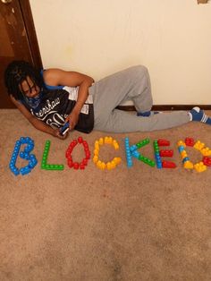 a person laying on the floor with blocks spelling out blockies