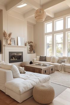 a living room filled with furniture and a fire place in front of two large windows