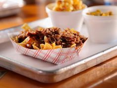 a tray with some food on it and two bowls next to it that are sitting on a table