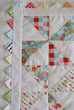 a quilted table topper with many different colors and designs on it, including the center piece