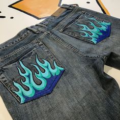 a pair of jeans with flames painted on them