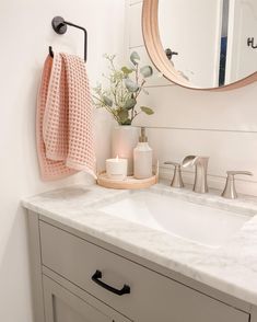 a bathroom with a sink, mirror and soap dispenser on the counter