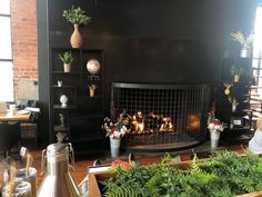 a fire place in the middle of a room with potted plants on either side