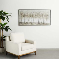 a white chair sitting next to a potted plant in front of a painting on the wall