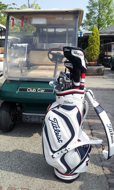 a golf bag sitting on the ground next to a cart