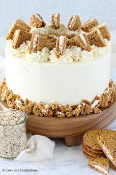 a cake with white frosting and cookies around it