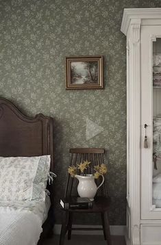 a bed sitting next to a white cabinet in a bedroom