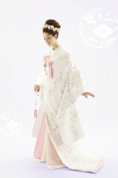 a woman in a white and pink kimono is holding a flower on her left hand