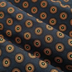 an image of a blue and gold fabric with green circles on the top of it