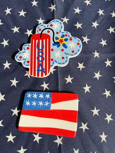 two magnets on top of a blanket with stars and an american flag design in the background