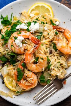 pasta with shrimp, fettuccine and lemon wedges on a white plate