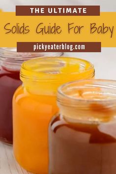 three jars filled with liquid sitting next to each other on a wooden table and text overlay reads the ultimate solids guide for baby