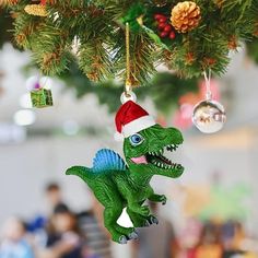 a toy dinosaur ornament hanging from a christmas tree