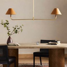 a dining room table with two lamps hanging over it