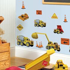 a child's room with construction themed wall decals and toys on the floor