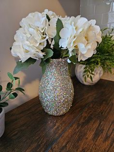 some white flowers are in a vase on a table