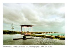 a gazebo sitting on top of a lush green field next to the ocean