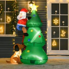 an inflatable christmas tree with santa and his dog on the front porch next to it