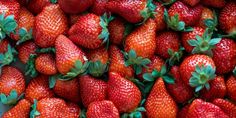 a bunch of strawberries that are laying on top of each other in a pile